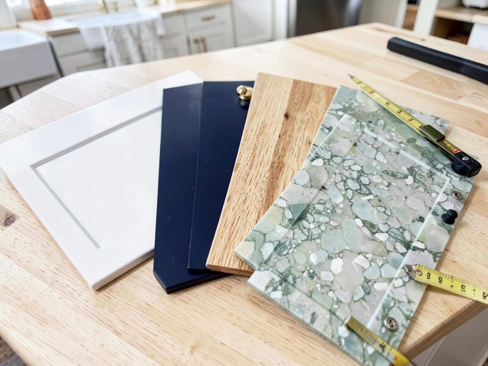 Cabinet door and finish samples laid out on a homeowner's counter with a tape measure